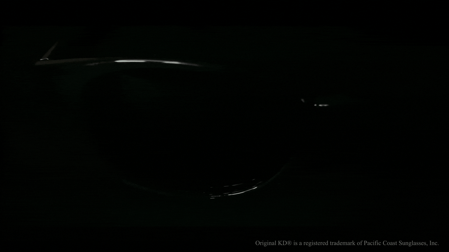 Ästhetisches Lichtspiel, das eine KD's-Sonnenbrille im Dunkeln hervorhebt und ihr elegantes Design und ihre hohe Qualität unterstreicht.